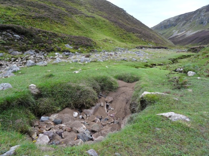 A large spring (not running) in the centre of the valley. Also dry river bed showing behind it.